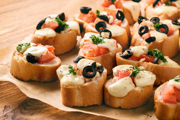 Baked toasts with mozarella, tomatoes, olives and garlic.