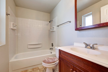 Naklejka na ściany i meble White bathroom with mahogany vanity cabinet