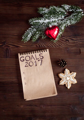 notebook and goals for new year wooden background top view