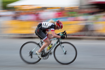 A female rider participating in a criterum road race.