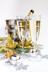 glasses of champagne and Christmas ornaments on white background