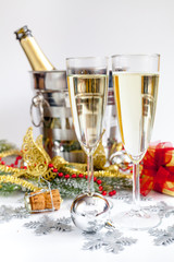 glasses of champagne and Christmas ornaments on white background