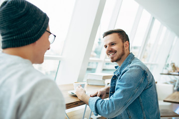 Obraz premium Men are sitting in front of the table near window