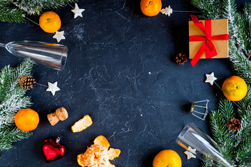 glasses and Christmas ornaments on dark background top view