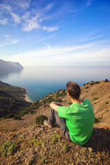 Traveler man sitting on top of mountain.