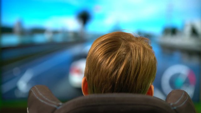 Teenager are playing in the car race with the wheel of a game console.