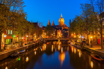 Fototapeta na wymiar Church of St Nicholas and red lights quater over old town canal at night, Amsterdam, Holland