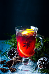 Mulled wine and spices on wooden background.