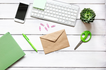 female wooden desktop with smartphone, notebook and flowers top view