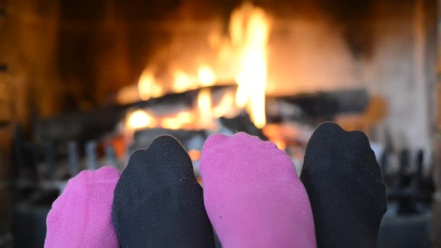 Feet heated on a fireplace