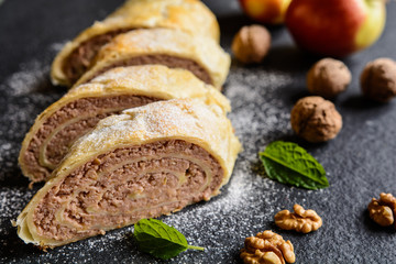 Sweet strudel stuffed with walnut and apple filling