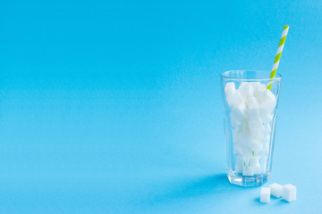 Glass with straw full of sugar cubes. Lot of sugar, cocktail