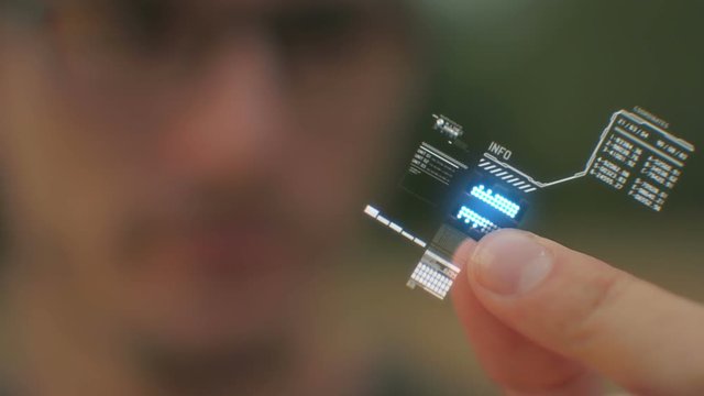 Shot of a person holding a computer processor with a holographic interface.