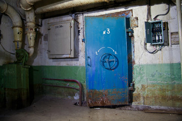 Blue rusty hermetical door of old abandoned Soviet bomb shelter 