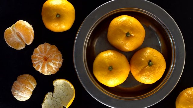 Frash tangerines on black background.