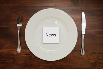 White piece of paper with a word NEWS on a plate on a wooden tab