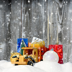 Christmas background.Toy truck with gifts, New Year fir and balls in the snow