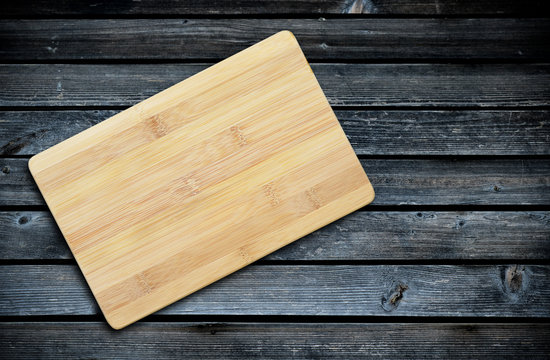 Empty bamboo cutting board on a old wooden table for product display.Top view