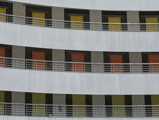 3 floors of different coloured doors in building facade