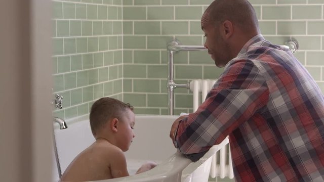 Father And Son Having Fun At Bath Time Together