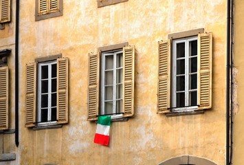 Fototapeta na wymiar old window with flag in Bergamo Italy