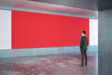 Man looking at red billboard