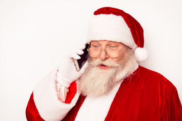 Funny Santa Claus wearing red costume talking on phone  while st