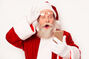 Portrait of excited Santa looking on clock on smartphone and und