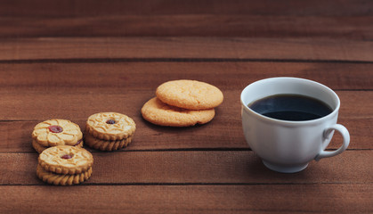 Cup of hot coffee and cookies on wooden background. copy space for text