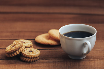 Cup of hot coffee and cookies on wooden background. copy space for text