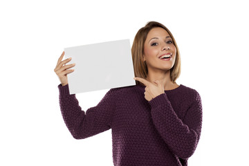 happy young woman holding a blank sheet of paper for advertising
