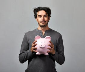 Young man with piggy bank.