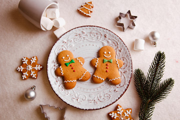 Gingerbread men lying on a plate. Christmas background