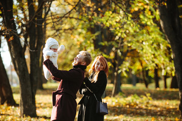 young family and newborn son in autumn park