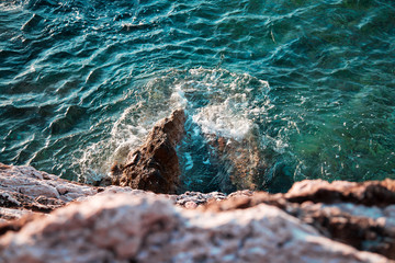 Clear blue sea waves and stone coast