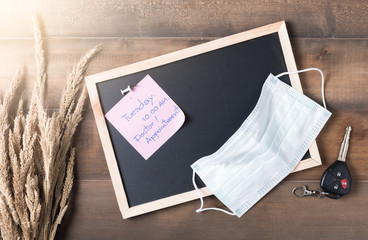 paper note doctor appointment on blackboard wiith healthy mask