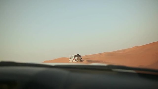 Desert Safari SUVs bashing through the arabian sand dunes. View from the car 9.