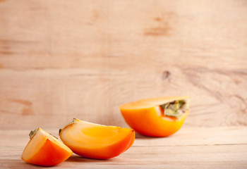 Ripe fresh persimmon on wood board