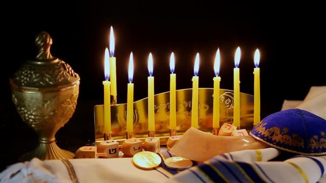 Jewish holiday hannukah low key image of jewish holiday Hanukkah with menorah traditional Candelabra and wooden dreidels spinning top . glitter overlay
