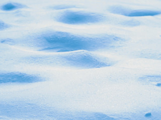 Fototapeta na wymiar Blue bumpy mound snow surface background, shallow depth of field