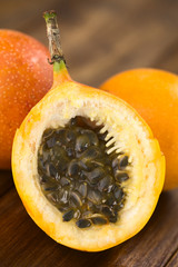 Längsschnitt einer süßen Granadilla (lat. Passiflora ligularis), von der das süße saftige Fruchtfleisch und die weichen Kerne gegessen werden (Selektiver Fokus, Fokus auf die vorderen Kerne)