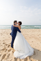 Loving couple embracing on the beach on a sunny day