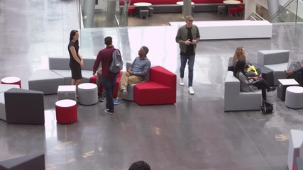 Students socialise and meet in a university lobby, shot on R3D