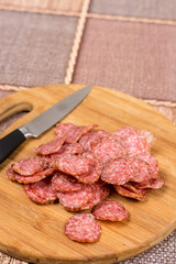 Flat lay overview sliced sausage on the wooden board