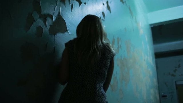 exhausted girl goes hand in wall, physical violence concept