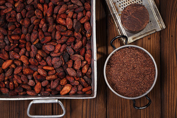 grated dark chocolate in tin with cocoa beans and solid piece in
