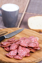 Sliced sausages on the wooden board with bread