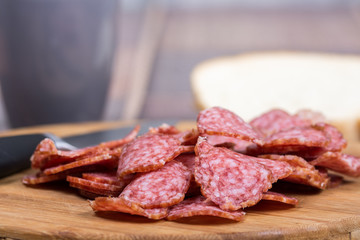 Sliced sausages on the wooden board with bread
