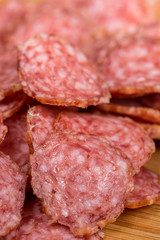 Sliced sausages on the wooden board with bread