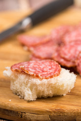 Sliced sausages on the wooden board with bread